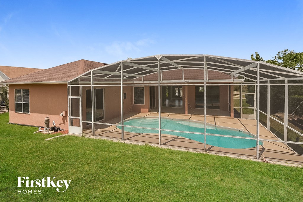 a patio with a pool in front of a house