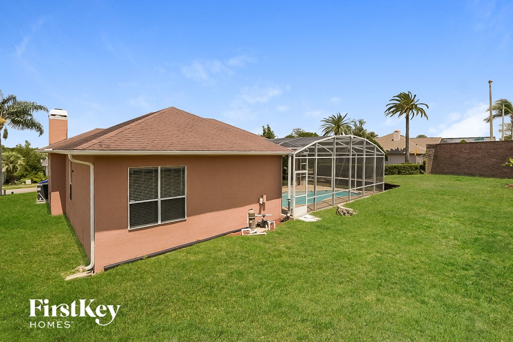 a backyard with a pool and a house with a greenhouse