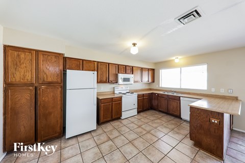 A kitchen with wooden cabinets and a white refrigerator.