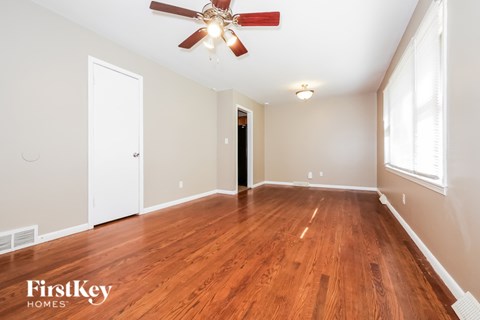 A room with wooden floors and a ceiling fan.
