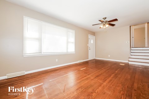 A room with wooden floors and a ceiling fan.
