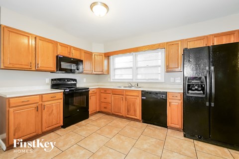 A kitchen with wooden cabinets and black appliances.