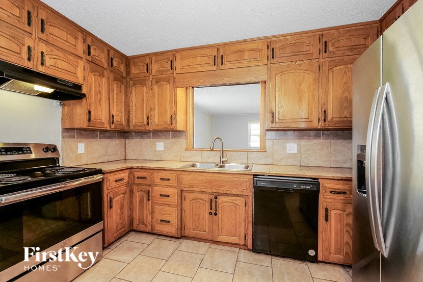 a kitchen with wooden cabinets and a sink and a refrigerator