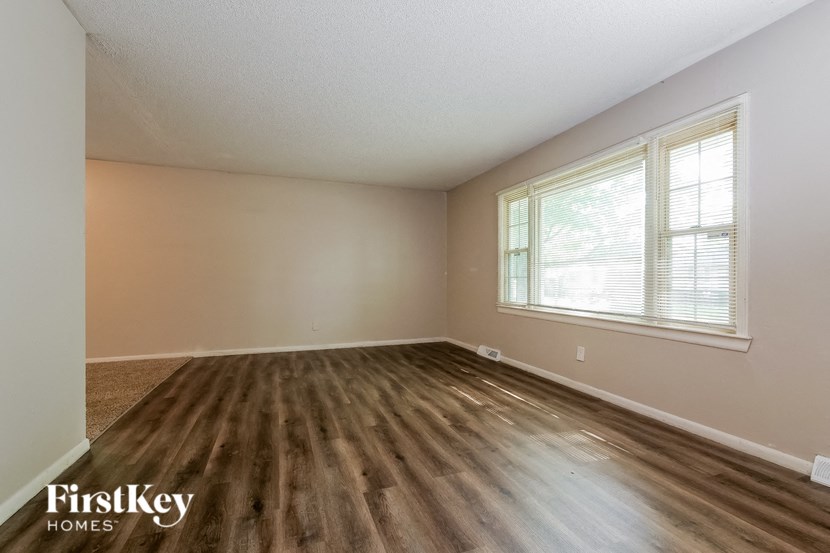 the living room of an empty house with wood floors