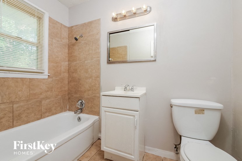 a bathroom with a tub and a toilet and a sink