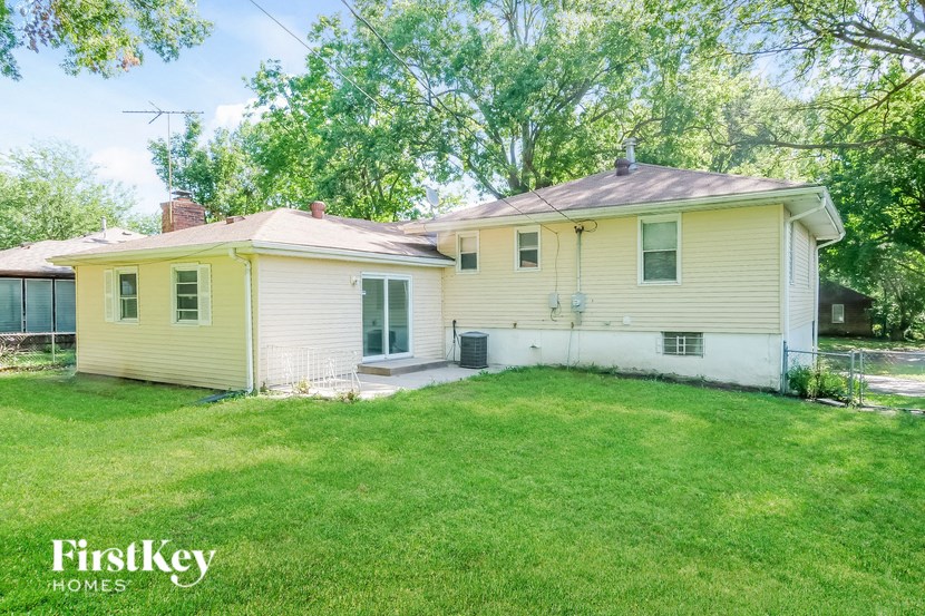 a white house with a grassy yard and a fence