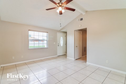 the living room and dining room are spacious and clean with a ceiling fan