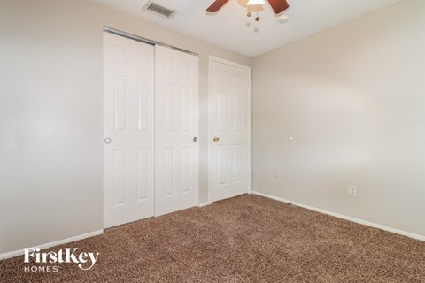 a bedroom with two closets and a ceiling fan