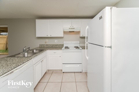 a kitchen with white appliances and white cabinets