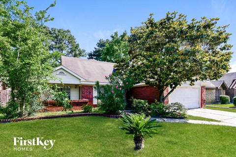 a home with a lawn and trees in front of it