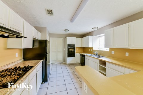 a kitchen with white cabinets and black appliances
