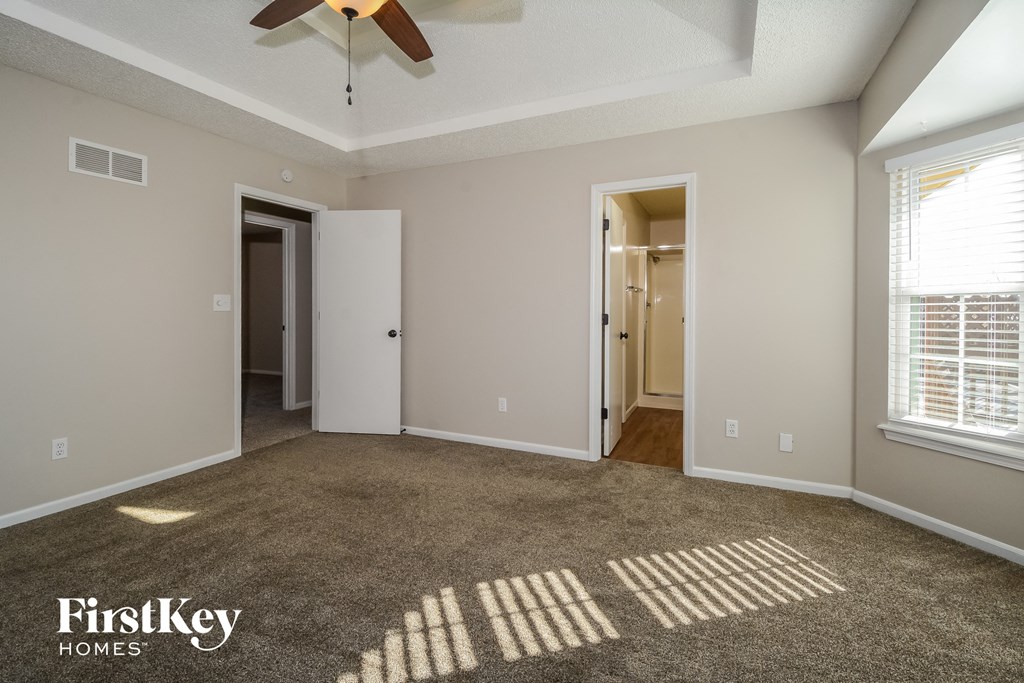 a living room with a carpeted floor and a ceiling fan