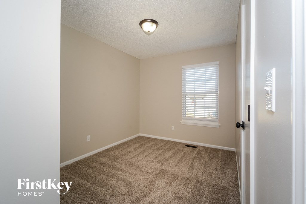 an empty room with carpet and a window