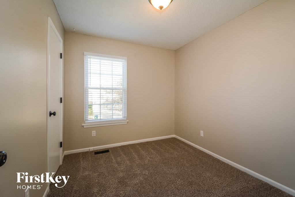 a bedroom with a carpeted floor and a window