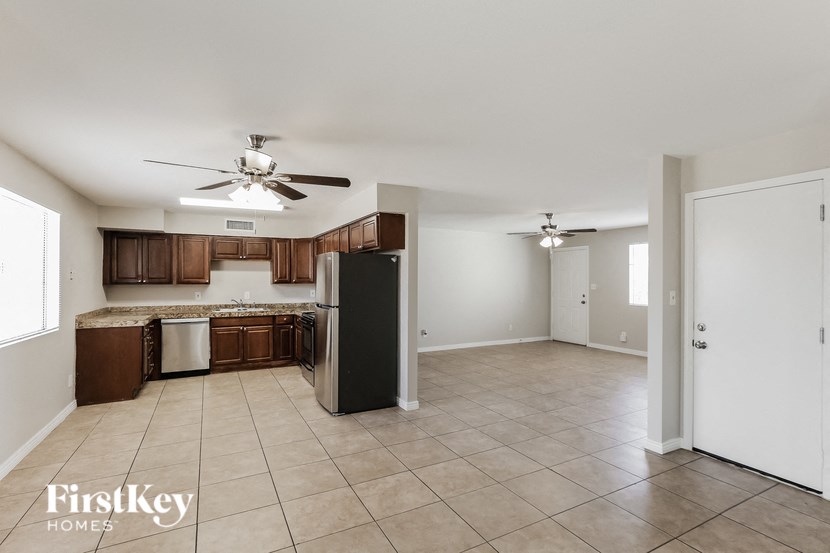 an empty kitchen and living room with a ceiling fan