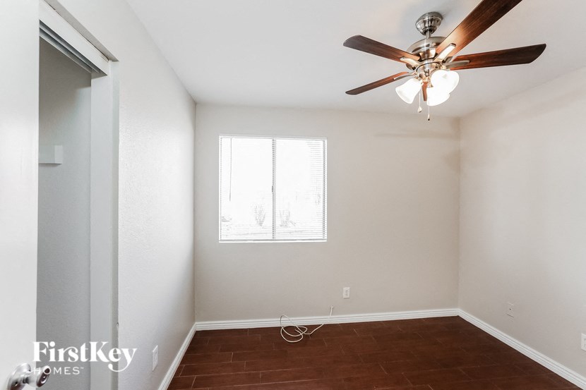 a empty room with a ceiling fan and a window