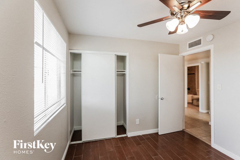 a living room with a ceiling fan and a closet