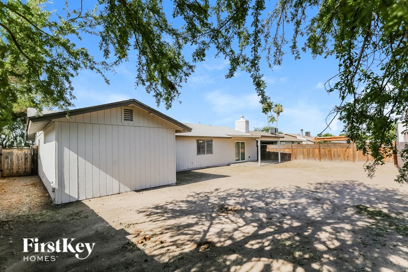 a white garage with a driveway and a white house