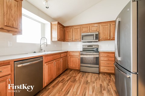 A kitchen with wooden cabinets and a stainless steel refrigerator.