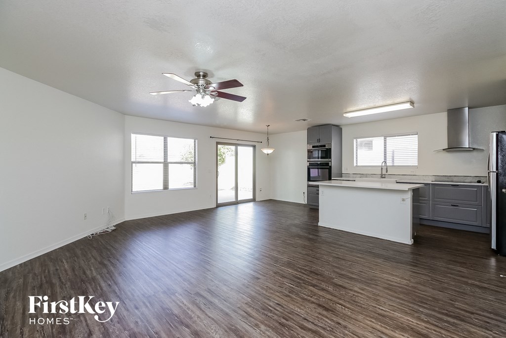an empty kitchen and living room with a ceiling fan