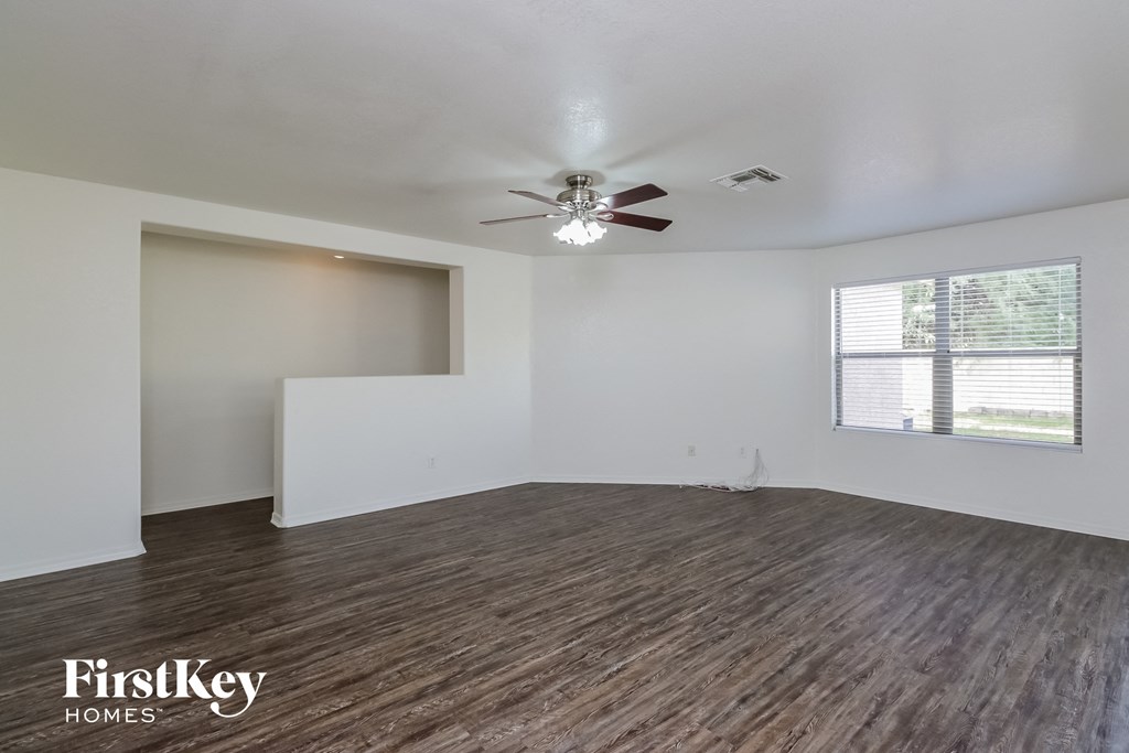 a living room with a ceiling fan and a window