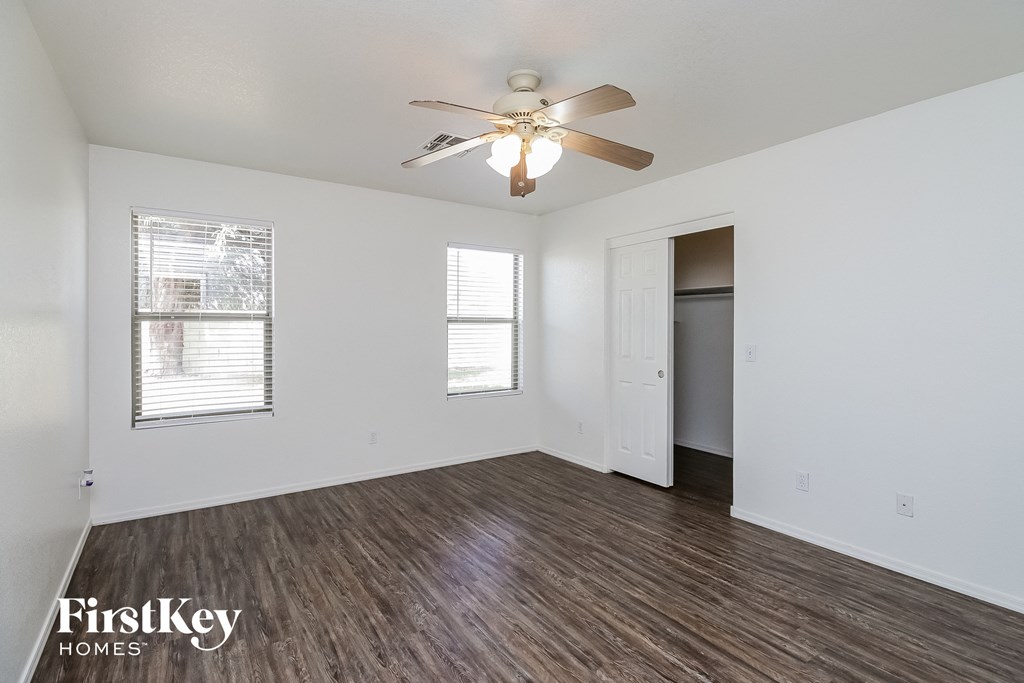 the living room of an empty house with a ceiling fan