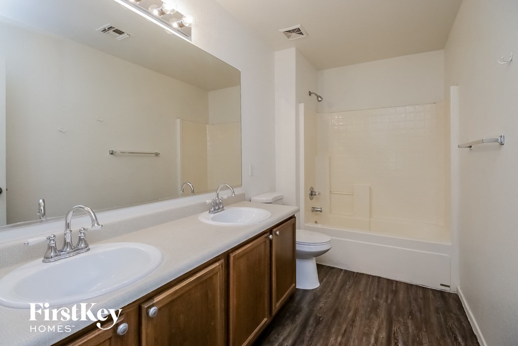 a bathroom with two sinks and a toilet and a bath tub