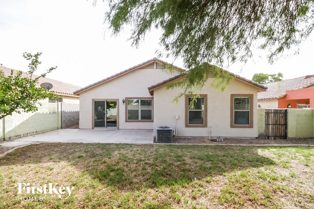 a white house with a driveway and a tree