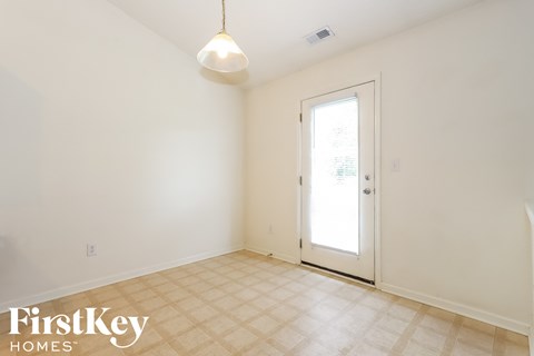 A room with a door and a light hanging from the ceiling.