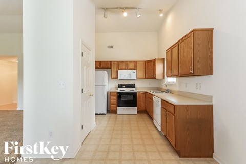 A kitchen with wooden cabinets and a white refrigerator.