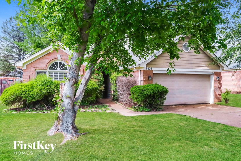 a home with a garage and a tree in the yard