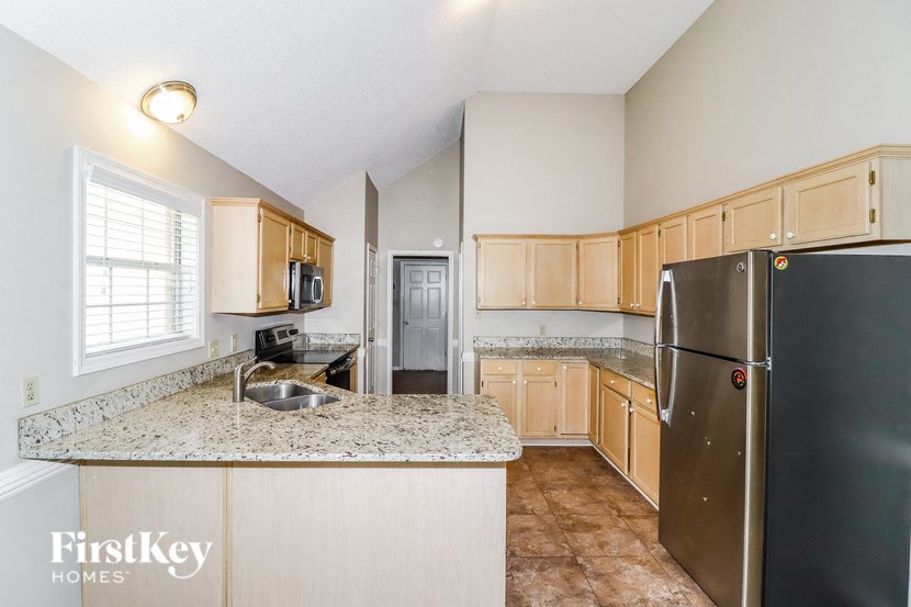 the kitchen has granite counter tops and wooden cabinets and stainless steel appliances