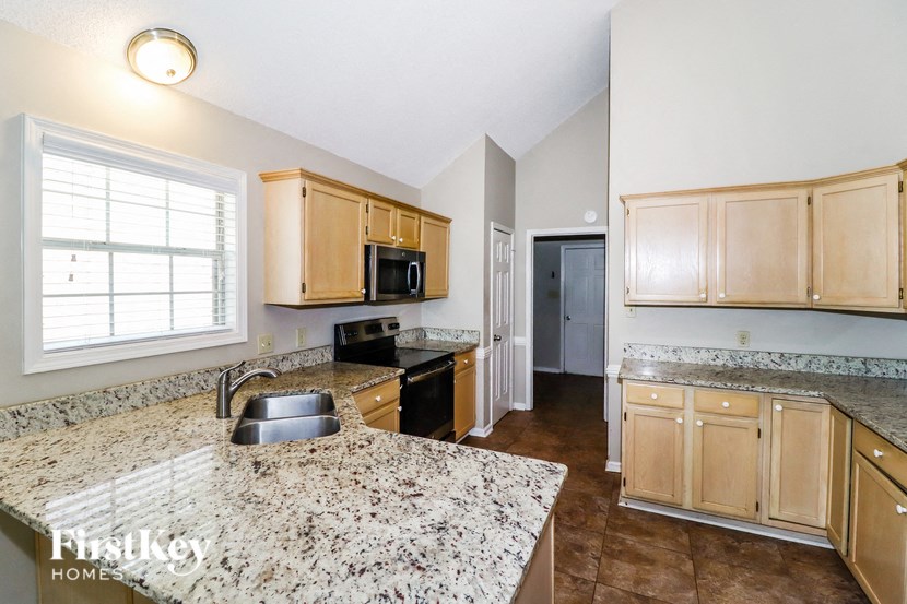 a kitchen with granite counter tops and wooden cabinets