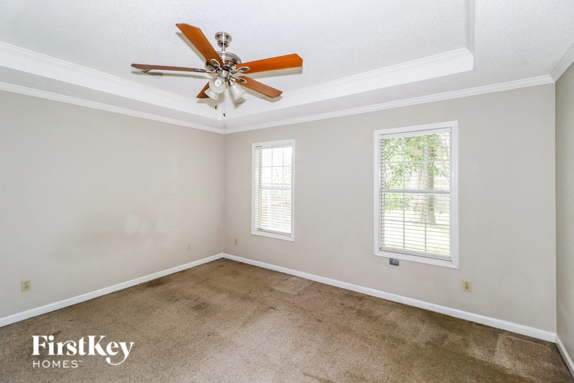 the living room of an empty house with a ceiling fan