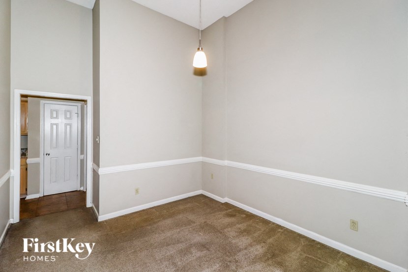 a living room with white walls and carpet and a white door