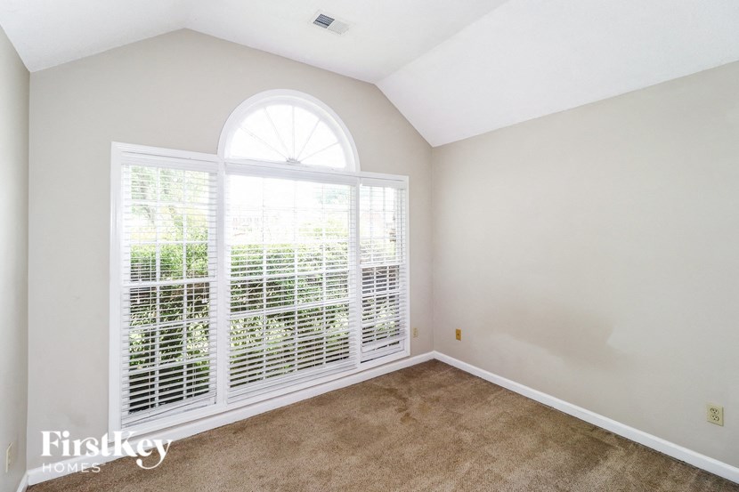 an empty room with a large window and a carpet