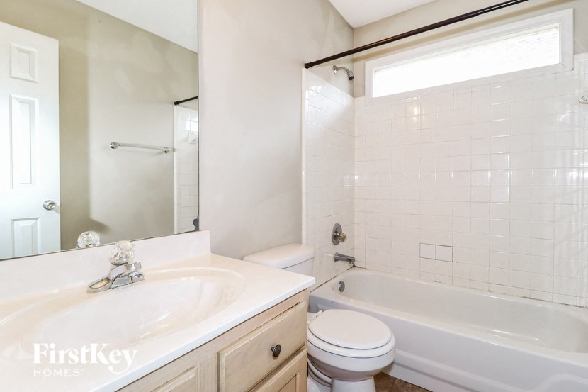 a white bathroom with a tub and a sink and a toilet