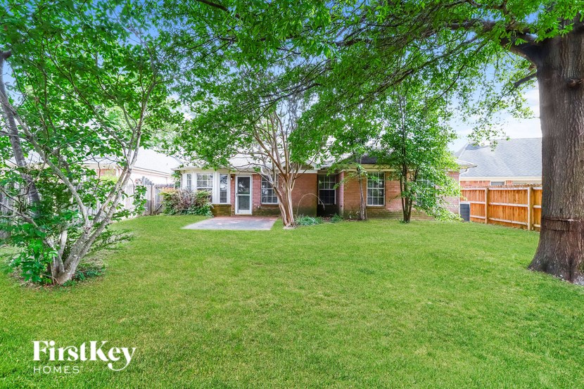 a backyard with trees and a house