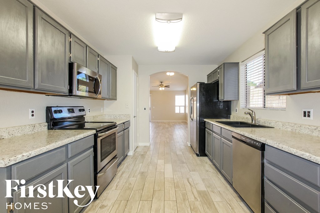 an empty kitchen with stainless steel appliances and white counter tops