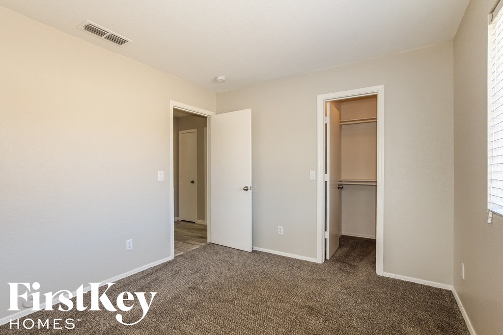 a bedroom with a carpeted floor and a door to a closet