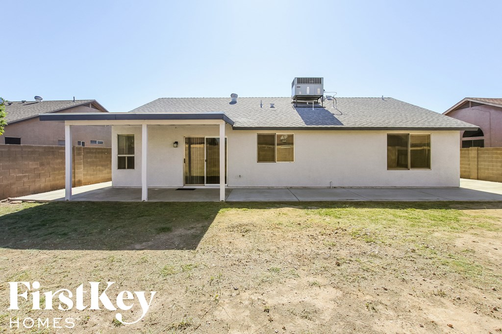 a white house with a patio and a grass yard