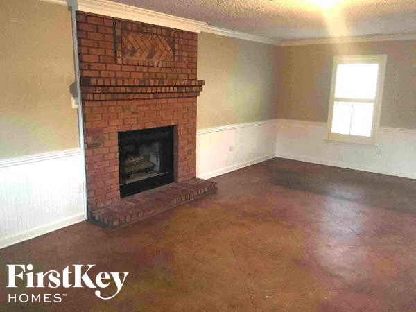 A room with a brick fireplace and a window.