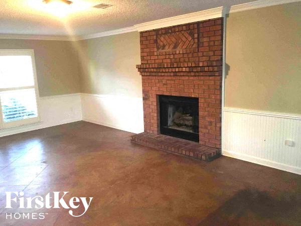 A brick fireplace in a room with a window.