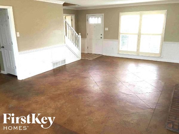 A room with a brown floor and white walls.