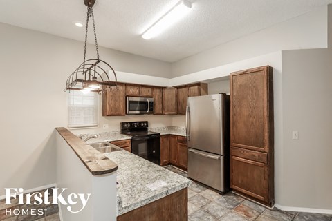 a kitchen with wooden cabinets and a stainless steel refrigerator