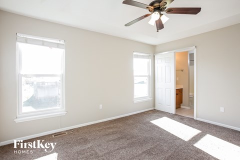 a living room with carpet and a ceiling fan