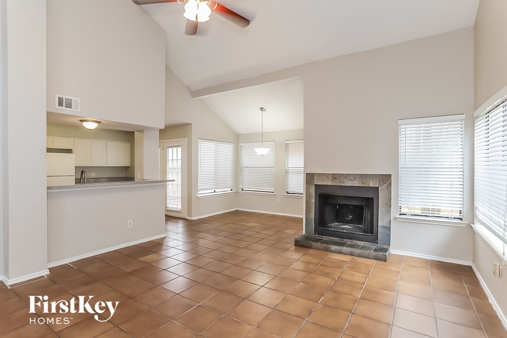a living room with a fireplace and a kitchen
