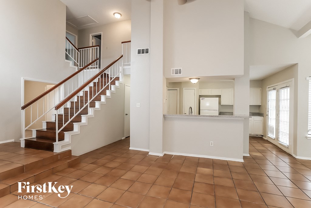 a view of the entryway of a home with a staircase and a kitchen