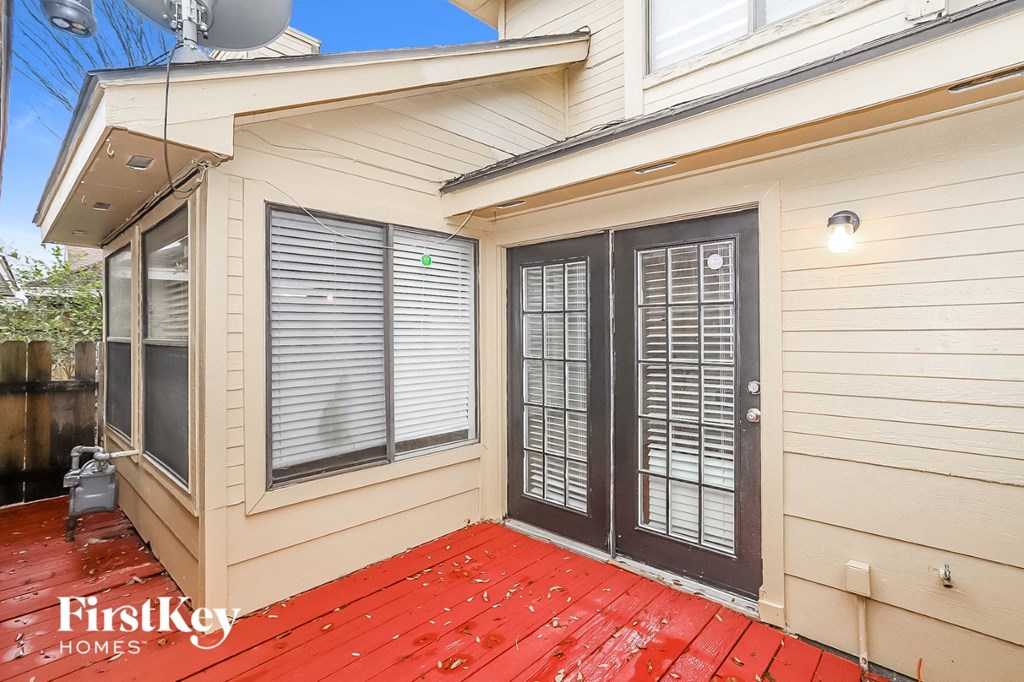 the front porch of a house with a red wood deck