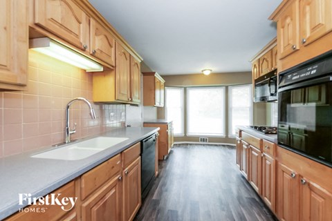 a kitchen with wooden cabinets and a sink and a window